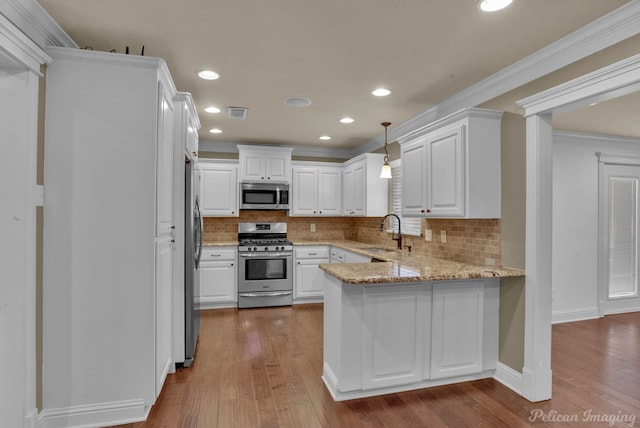 kitchen featuring white cabinetry, appliances with stainless steel finishes, and hardwood / wood-style flooring