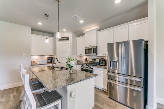 kitchen with light wood-type flooring, white cabinetry, appliances with stainless steel finishes, and sink