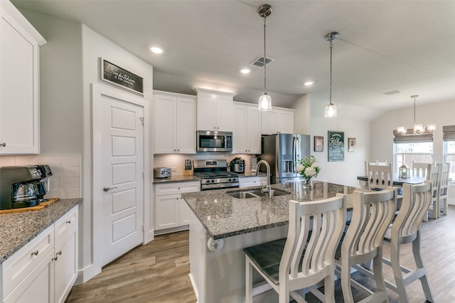 kitchen with light wood-type flooring, sink, stainless steel appliances, and white cabinets