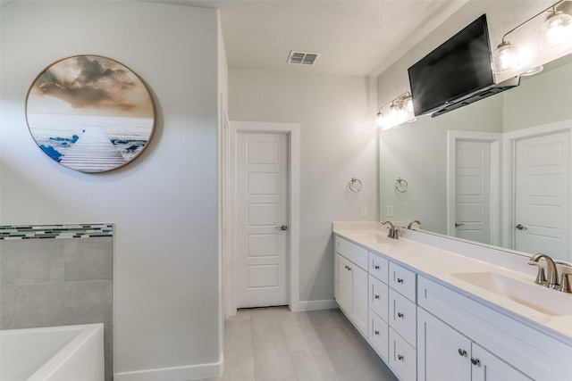 bathroom featuring tile patterned floors, a washtub, and vanity