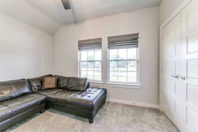 carpeted living room featuring ceiling fan and lofted ceiling