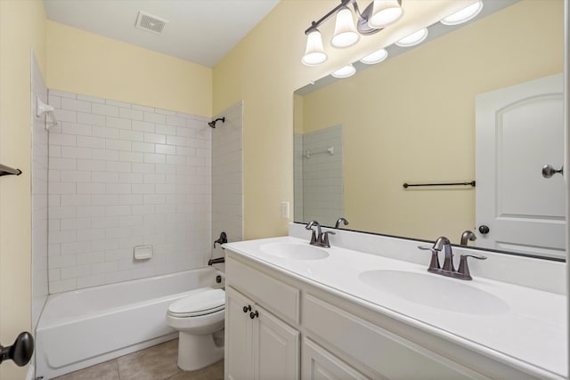 full bathroom featuring tiled shower / bath combo, vanity, toilet, and tile patterned floors