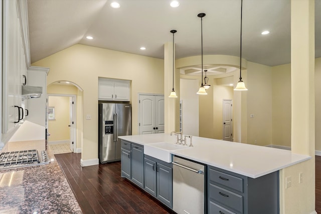 kitchen featuring white cabinetry, stainless steel appliances, decorative light fixtures, a center island with sink, and dark hardwood / wood-style floors