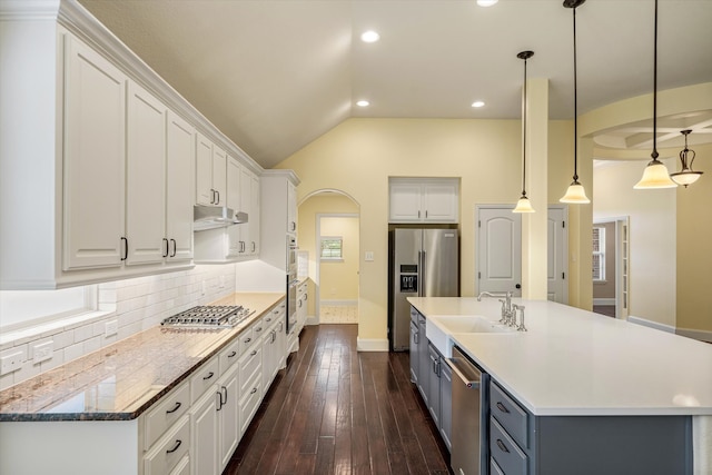 kitchen with dark wood-type flooring, white cabinets, pendant lighting, stainless steel appliances, and sink