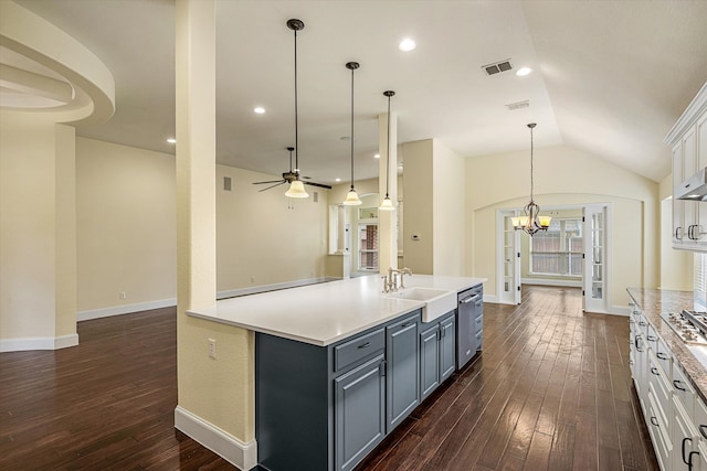 kitchen featuring dark hardwood / wood-style floors, sink, ceiling fan with notable chandelier, white cabinets, and hanging light fixtures