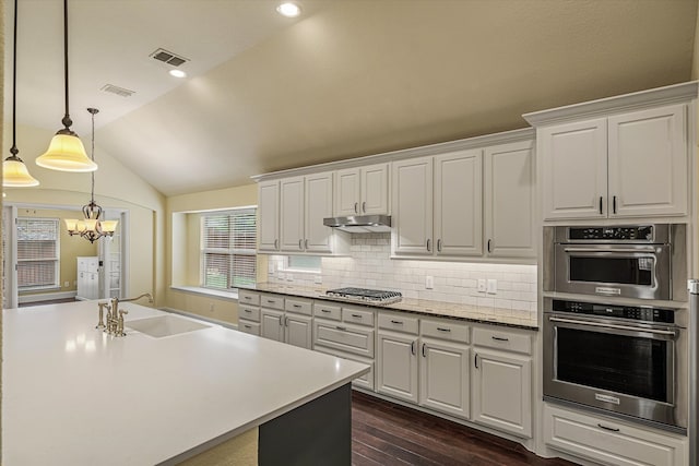 kitchen featuring pendant lighting, sink, white cabinetry, dark hardwood / wood-style floors, and vaulted ceiling