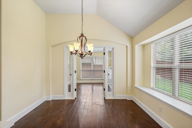 unfurnished dining area with a notable chandelier, lofted ceiling, and dark hardwood / wood-style floors