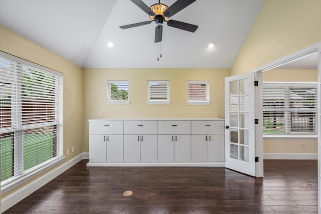 empty room featuring high vaulted ceiling, ceiling fan, dark hardwood / wood-style floors, and plenty of natural light