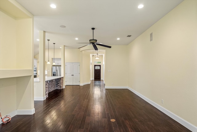 unfurnished living room featuring ceiling fan and dark wood-type flooring