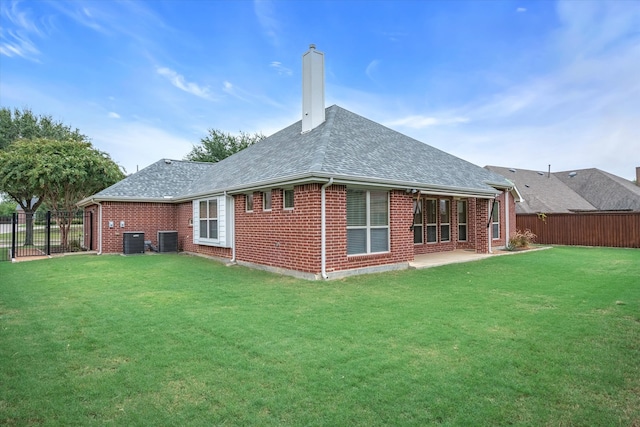 rear view of house with a patio area, central air condition unit, and a yard