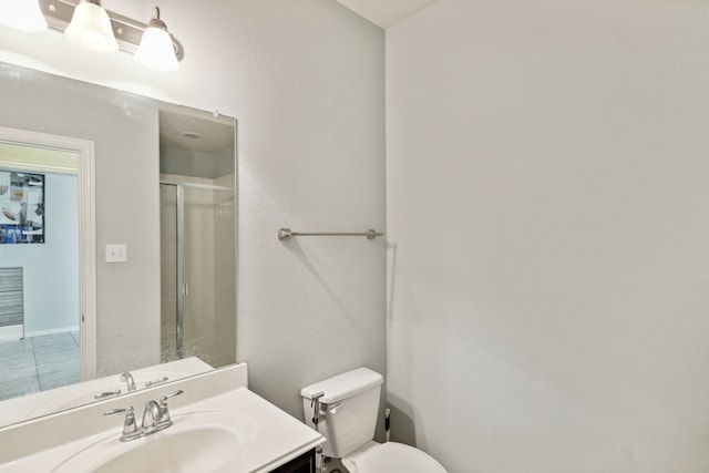 bathroom featuring tile patterned floors, a shower with door, vanity, and toilet