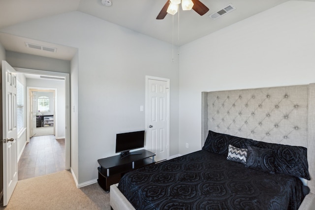 bedroom with ceiling fan, lofted ceiling, and light wood-type flooring