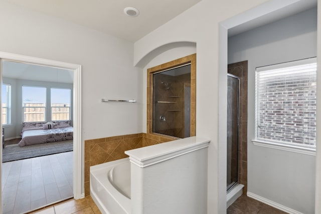 bathroom with shower with separate bathtub and tile patterned floors