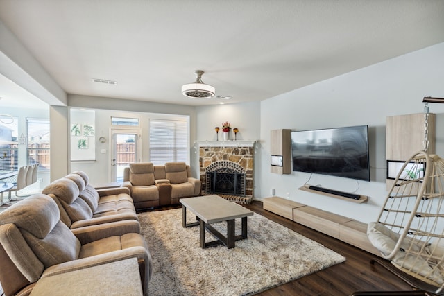 living room featuring a stone fireplace and hardwood / wood-style floors