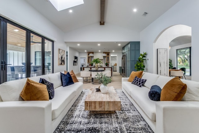 living room with beamed ceiling, light hardwood / wood-style flooring, and high vaulted ceiling