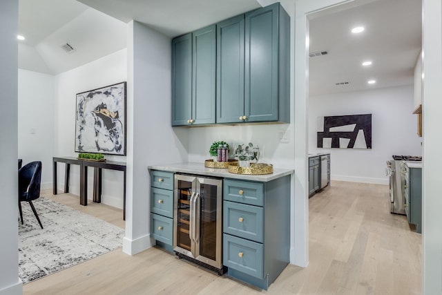 bar featuring gas stove, wine cooler, and light hardwood / wood-style flooring