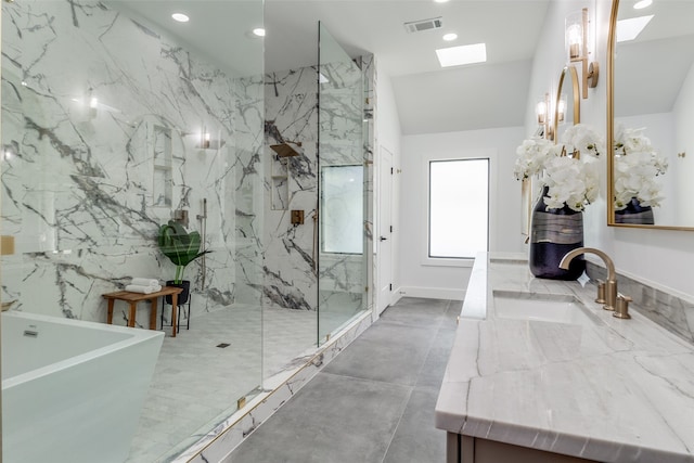 bathroom featuring a skylight, vanity, and plus walk in shower