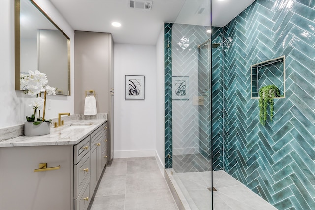 bathroom featuring tile patterned floors, vanity, and tiled shower