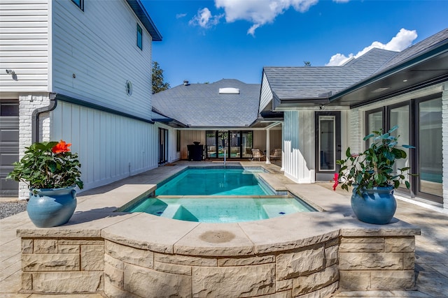 view of swimming pool with an in ground hot tub and a patio area