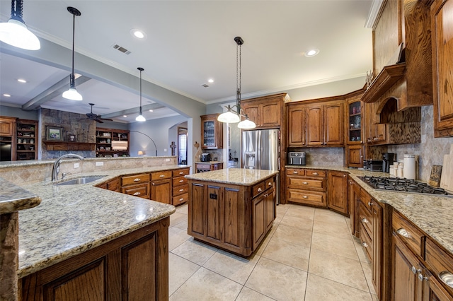 kitchen with pendant lighting, beam ceiling, a center island, ceiling fan, and sink