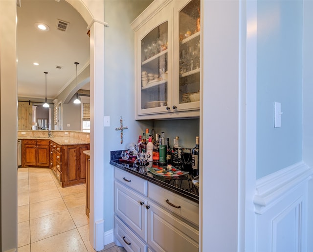 bar featuring dark stone countertops, white cabinets, pendant lighting, and ornamental molding