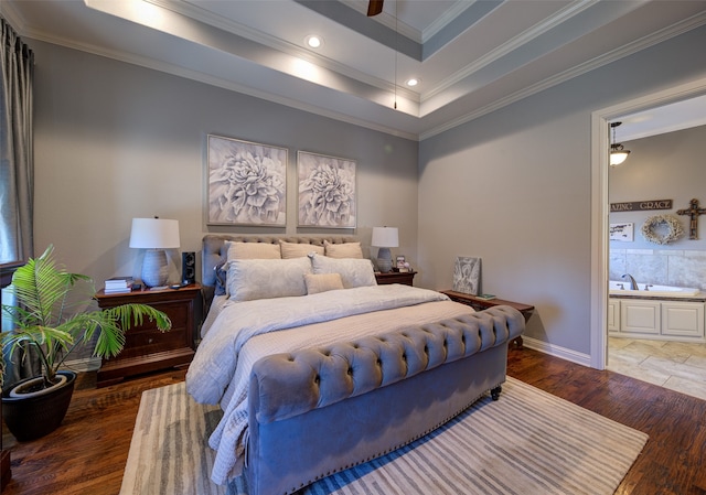 bedroom with dark wood-type flooring, ensuite bath, a raised ceiling, crown molding, and ceiling fan