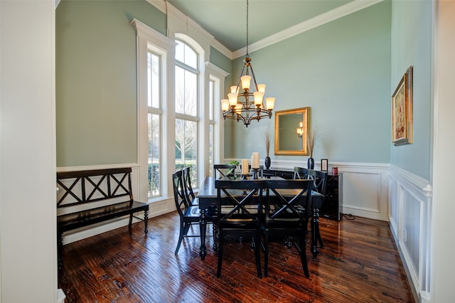 dining space with a wealth of natural light, a chandelier, crown molding, and dark hardwood / wood-style flooring