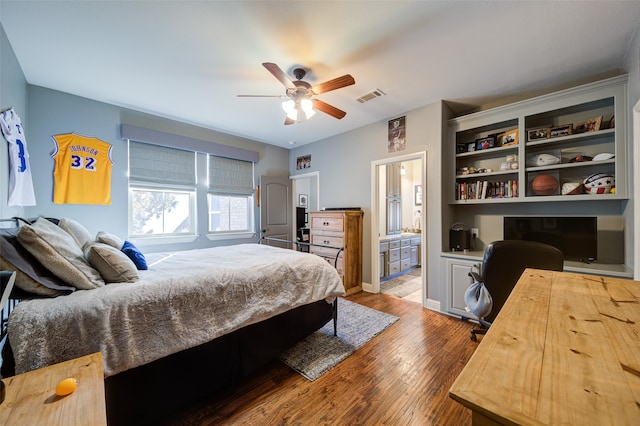 bedroom featuring hardwood / wood-style floors, ceiling fan, and ensuite bath