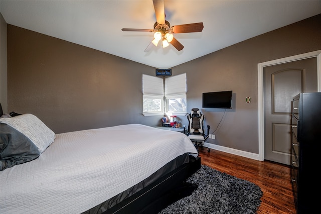 bedroom with dark hardwood / wood-style floors and ceiling fan