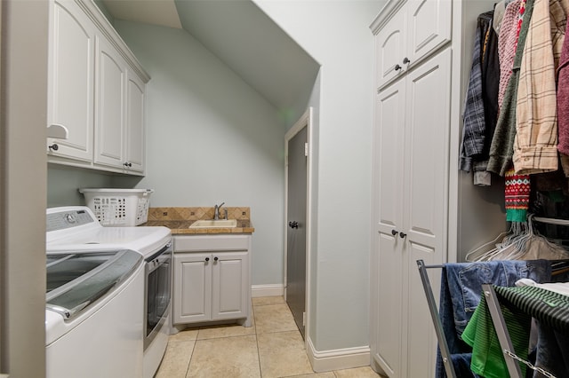 washroom featuring washer and clothes dryer, sink, light tile patterned floors, and cabinets