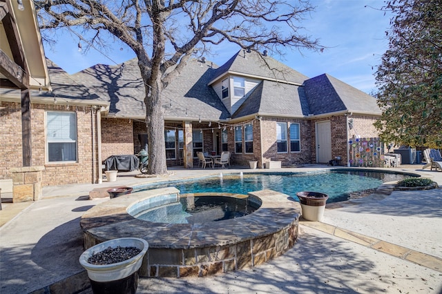 view of swimming pool with an in ground hot tub and a patio area