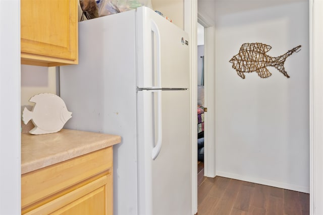 kitchen with white refrigerator, light brown cabinetry, and dark hardwood / wood-style floors