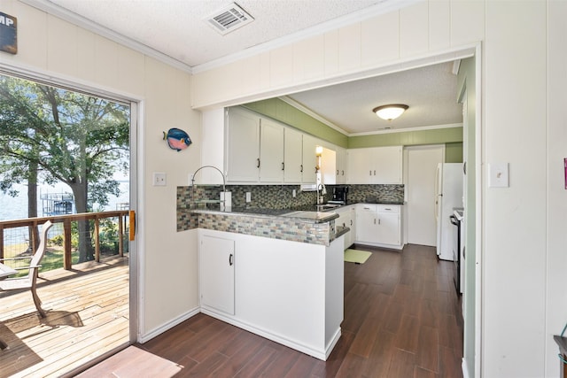 107 Briarwood Dr, Mabank, TX 75156 - kitchen featuring ornamental molding, dark wood-type flooring, decorative backsplash, visible vents, and a peninsula