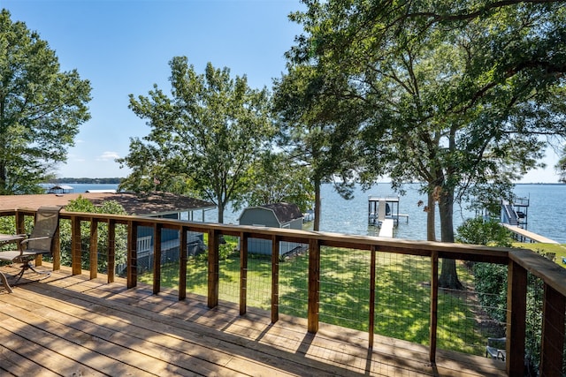 wooden terrace featuring a dock, a yard, and a water view