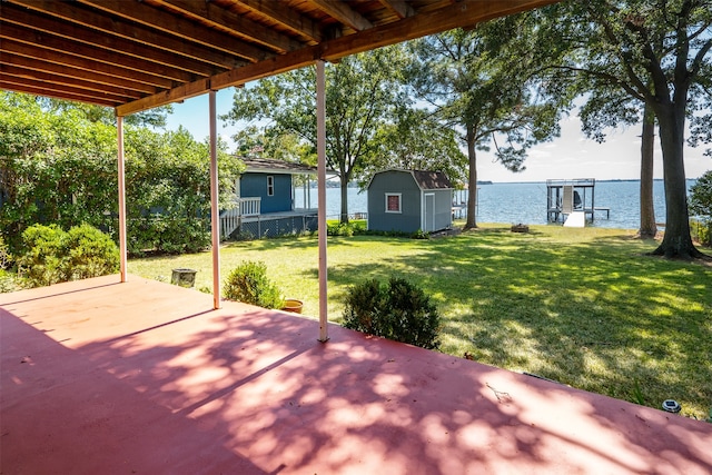 view of patio / terrace with a storage shed and a water view