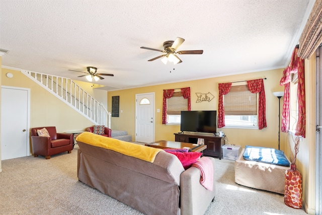 living room with ceiling fan, a textured ceiling, crown molding, and light carpet