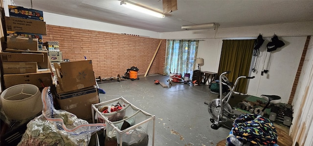 miscellaneous room featuring brick wall and concrete floors