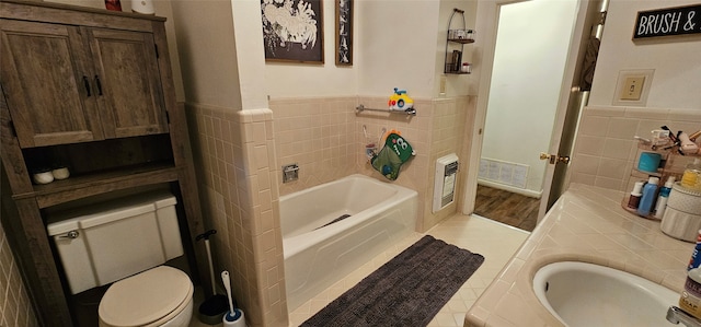 bathroom with a bathtub, toilet, sink, and hardwood / wood-style flooring