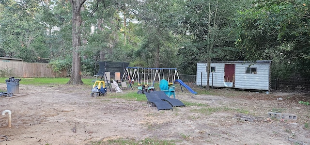 view of playground featuring a trampoline and a storage unit