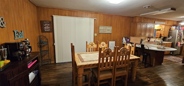 dining area with wood walls and dark hardwood / wood-style flooring