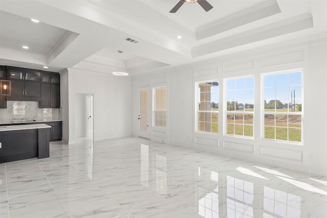 interior space with dark brown cabinets, a raised ceiling, decorative light fixtures, crown molding, and ceiling fan