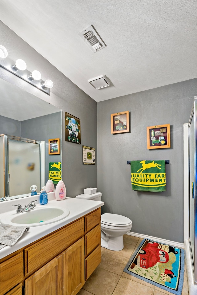 bathroom with vanity, tile patterned flooring, a shower with shower door, and toilet