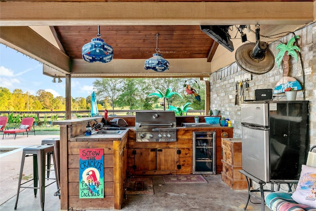 view of patio with area for grilling, sink, wine cooler, and a grill