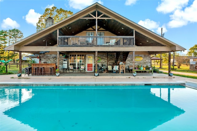 view of swimming pool with a patio and exterior bar