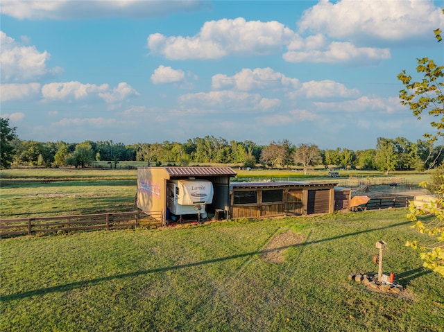 view of outbuilding with a rural view and a yard