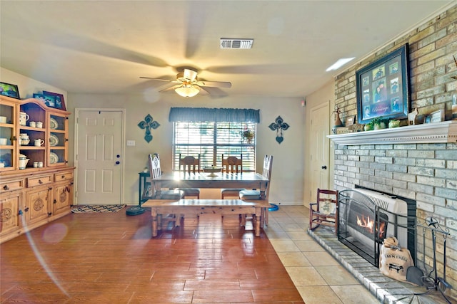 living room featuring a brick fireplace, ceiling fan, and wood-type flooring