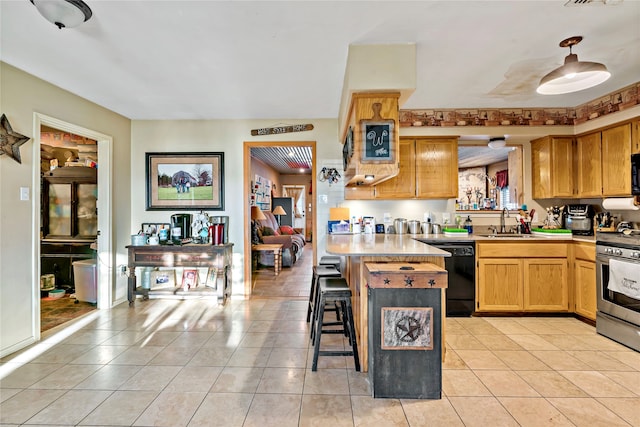 kitchen featuring a breakfast bar, dishwasher, light tile patterned flooring, sink, and stainless steel stove