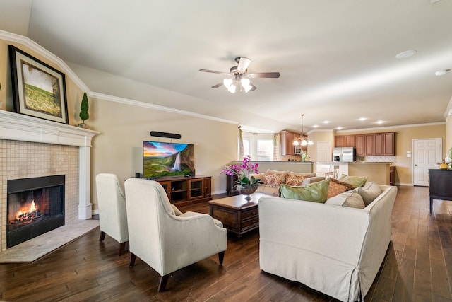 living room with crown molding, a fireplace, ceiling fan with notable chandelier, and dark hardwood / wood-style floors