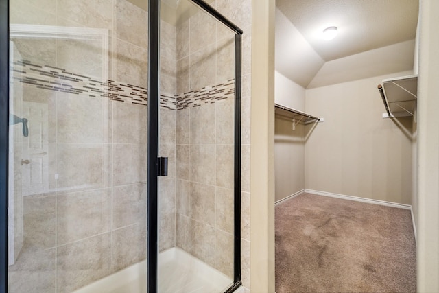 bathroom featuring walk in shower and vaulted ceiling