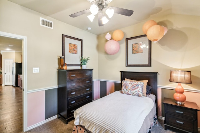 bedroom featuring dark wood-type flooring, stainless steel refrigerator, ceiling fan, and lofted ceiling